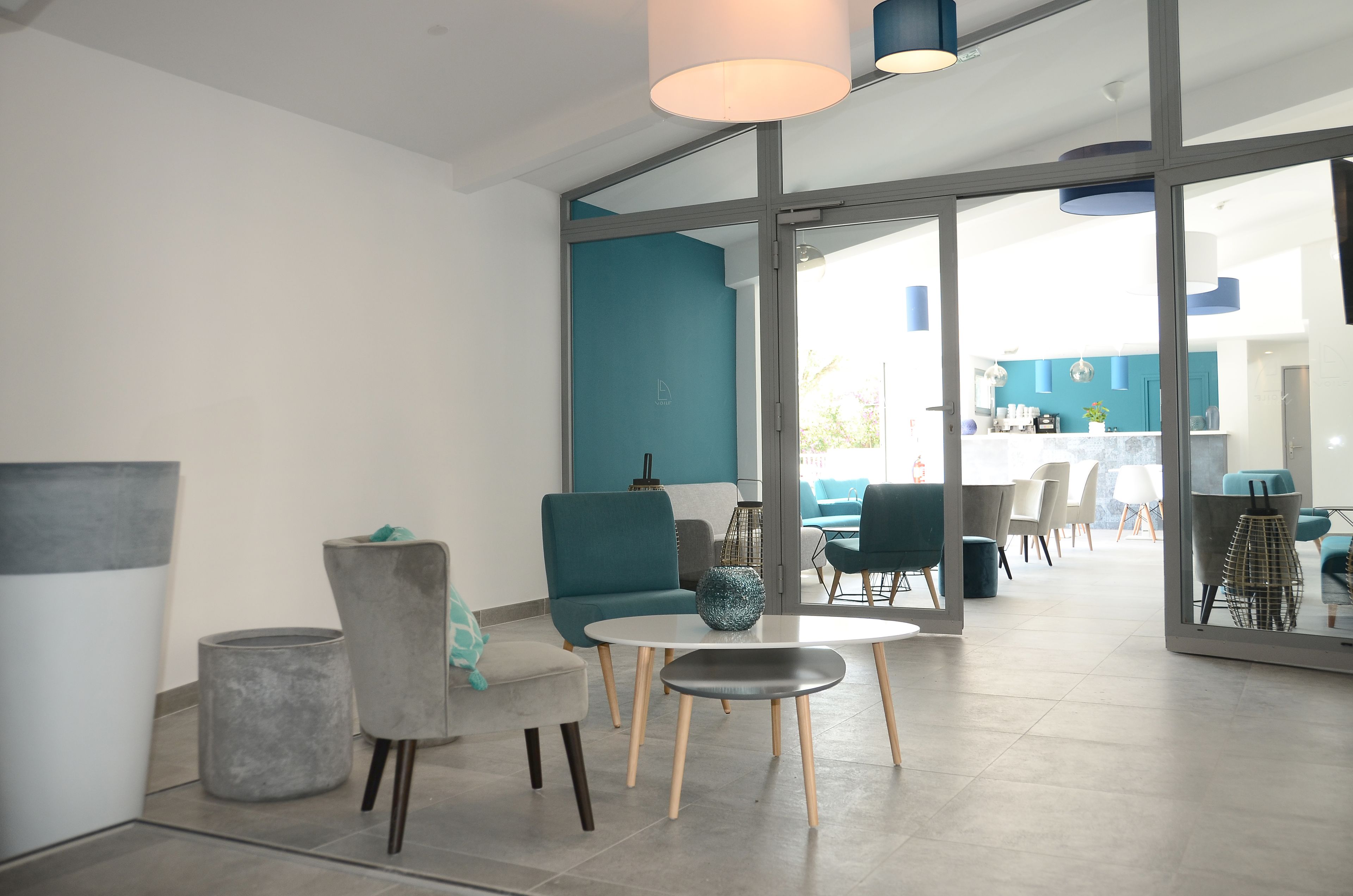 Een modern interieur met een zithoek, bestaande uit een ronde tafel, stoelen en een bank.