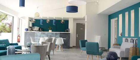 A modern interior with teal and white decor, a bar area, and seating arrangements.