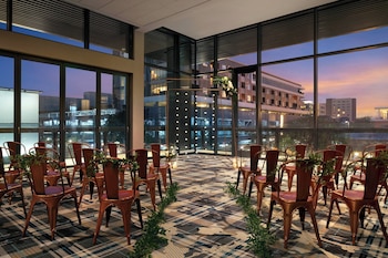 Enjoy a panoramic city view from the large window in this stylish room with a high ceiling and grid-like windows. at The Jacquard, Autograph Collection