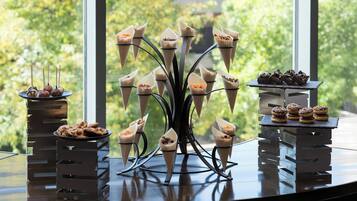 A dessert display with various confections on a table near a window.