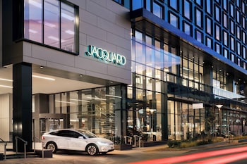 Welcome to JACQUARD, a contemporary building with a clean, geometric design and large glass windows. at The Jacquard, Autograph Collection