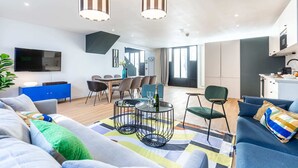 A modern living room with a sofa, a coffee table, and a dining area with chairs and a table. - Sweett | Brune II - Four Bedroom Apartment, Sleeps 10 (Paris)