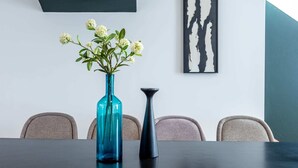 A conference table with a blue vase and a black vase, surrounded by four chairs. - Sweett | Brune II - Four Bedroom Apartment, Sleeps 10 (Paris)