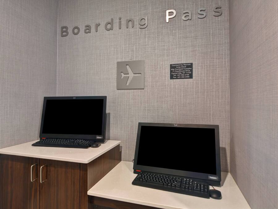 A desk with two laptops, a sign reading "Boarding Pass," and a directional sign.