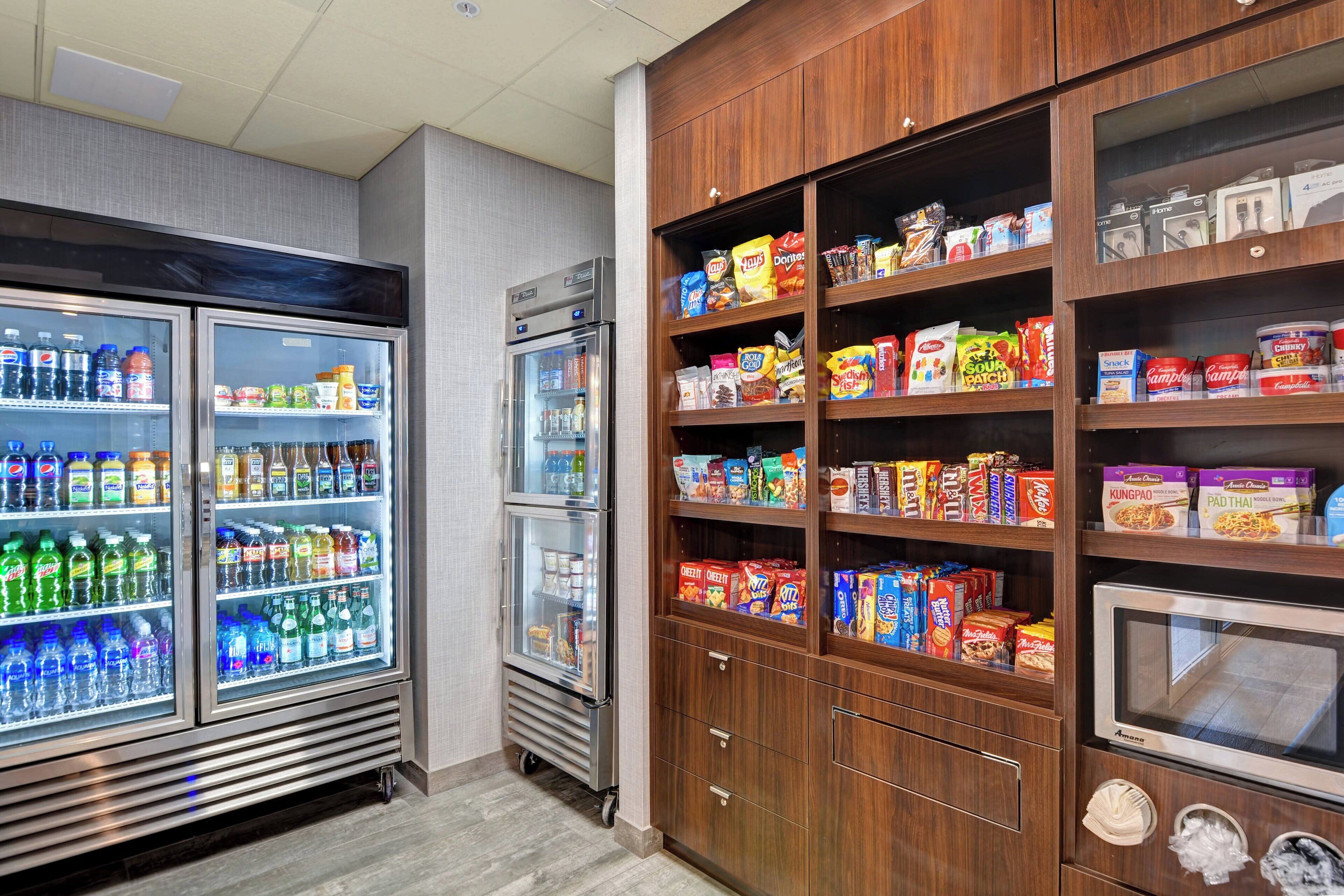 A well-stocked snack and beverage refrigerator with various drinks and snacks.
