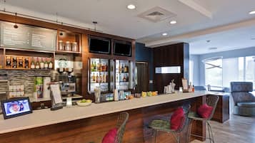 Un bar moderno con una barra larga, diversas opciones de asientos y una variedad de bebidas y alimentos exhibidos.