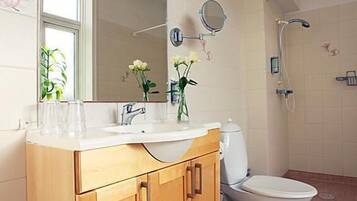 A modern bathroom with a wooden vanity, a large mirror, a toilet, and a shower.