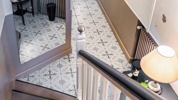 Una escalera con suelo estampado, una lámpara y un radiador.