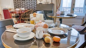 A dining table with breakfast items, a coffee pot, and a fruit bowl. - Hôtel Le Bretagne (Vannes)