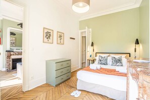 A bedroom with a bed, a dresser, a nightstand, and a door leading to another room. - Sweett | Saint Germain III (Paris)