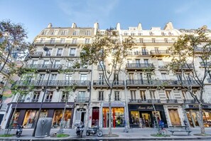 A multi-story building with storefronts on the ground floor, including a clothing store and a shoe store. - Sweett | Saint Germain III (Paris)
