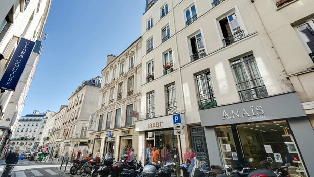 A street view with buildings, a 'Jakar' store, and parked motorcycles.