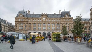 A large historic building with a central clock tower, surrounded by a public square with market stalls and people. - Sweett | Milan I - Two Bedroom Apartment, Sleeps 6 (Paris)