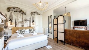 Ein Hotelzimmer mit Bett, Holzboden, einer Rezeption und einem Fernseher.