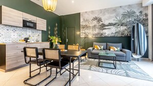 A modern kitchen with a microwave, a dining table with chairs, a sofa, and a large abstract sculpture. - Sweett | Ponthieu IV (Paris)