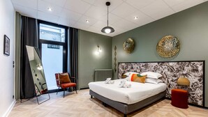 A modern hotel room with a large bed, a red chair, a mirror, and a view of the outside. - Sweett | Ponthieu IV (Paris)