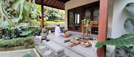 A covered outdoor area with a wooden structure, steps leading to a door, and various items on the steps.