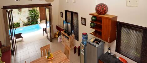 Cocina compacta con comedor, pequeña piscina y vistas al exterior.