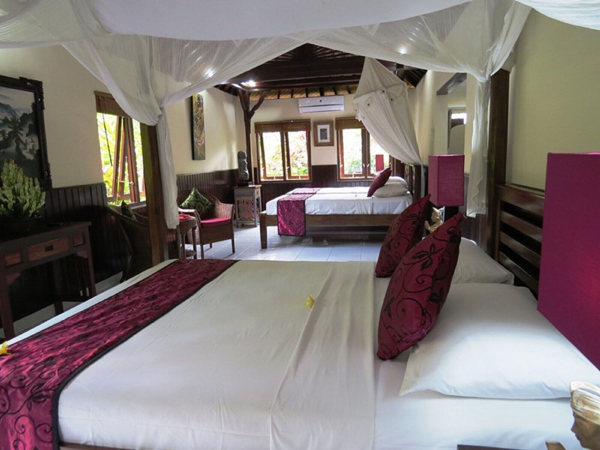 Une chambre d’hôtel avec un grand lit, un lit plus petit, un bureau et une chaise.