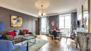 A modern living room with a sofa, coffee table, and dining area. - Sweett | Rivoli II - Three Bedroom Apartment, Sleeps 6 (Paris)