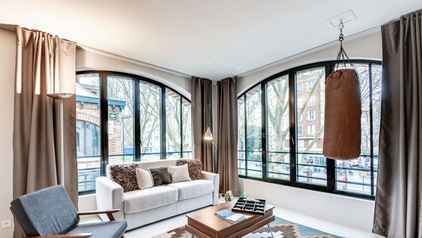 A modern living room with a white sofa, a wooden coffee table, and a patterned rug. - Sweett | Brune VIII - Three Bedroom Apartment, Sleeps 8 (Paris)