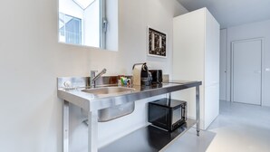 A modern kitchen with a stainless steel sink, a coffee machine, and a microwave. - Sweett | Brune VIII - Three Bedroom Apartment, Sleeps 8 (Paris)
