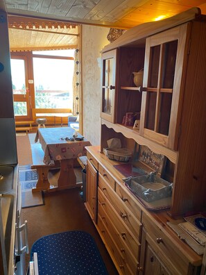 A cozy kitchen with wooden cabinets, a dining table, and a bench.