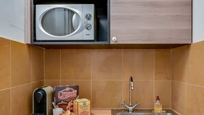 A compact kitchen with a microwave, a sink, and a small countertop area.