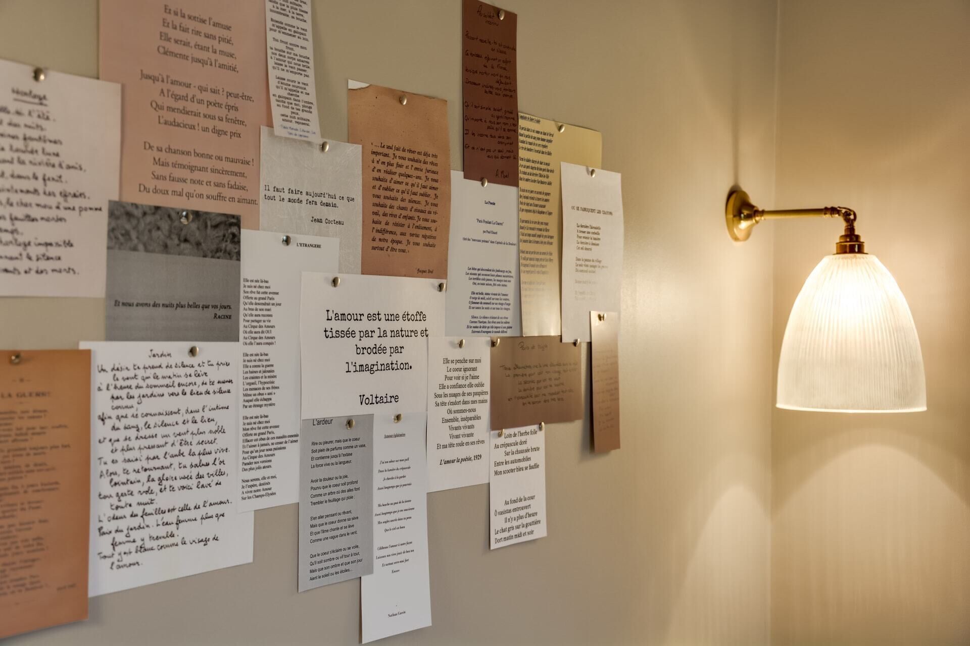 A wall with multiple papers pinned to it, some with text and others with handwritten notes.