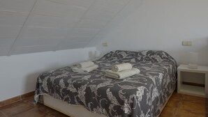 A bedroom with a bed, a nightstand, and a ceiling fan. - B&B Casa AriGiLi (Fuengirola)