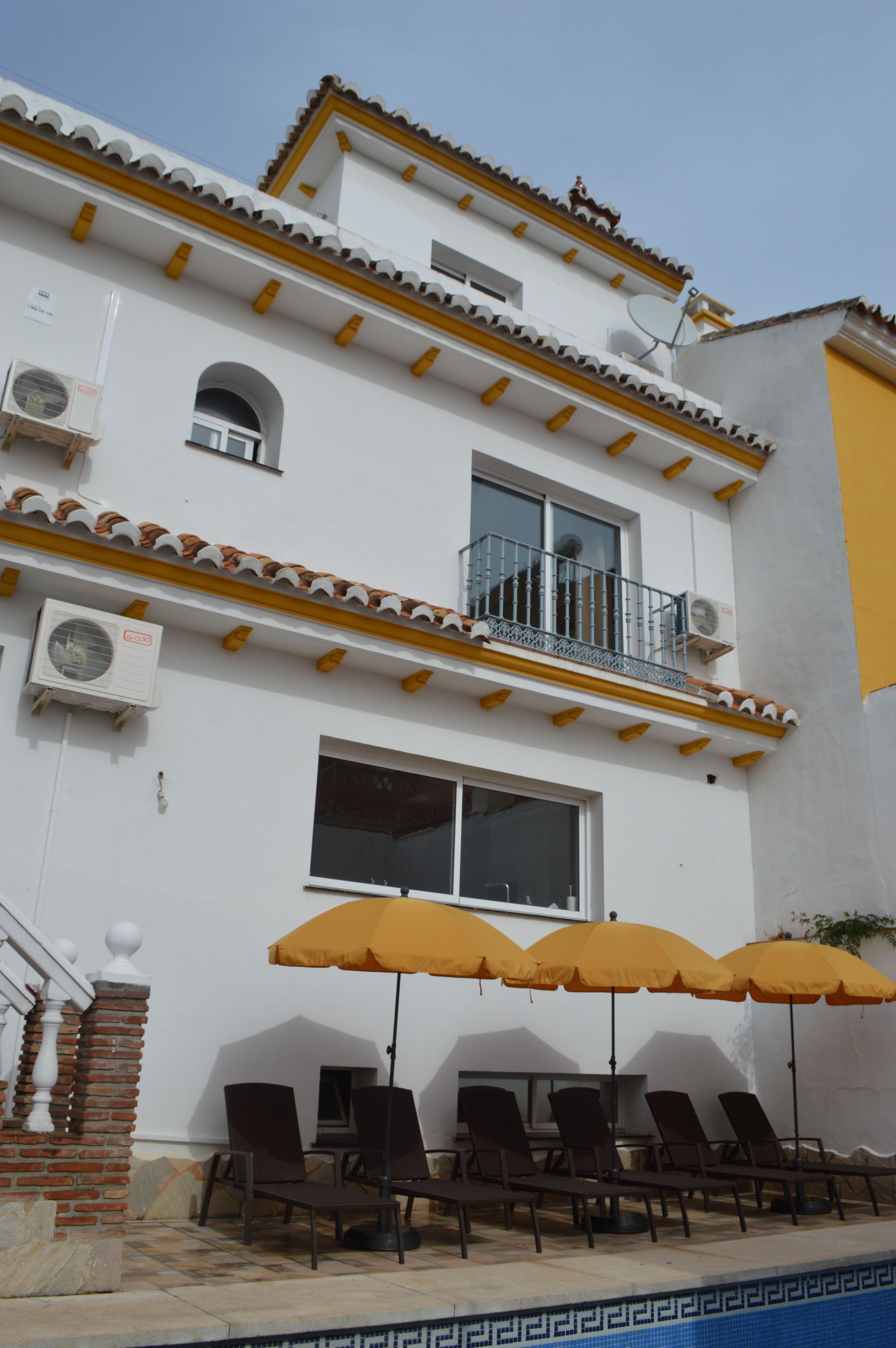 Een buitenzwembad, parasols voor strand/zwembad