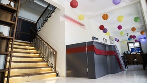 A staircase with wooden railings and a modern reception desk with a red accent.