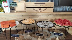 A food display with various fruits and a sign that reads "Drinking Water." - Bann Tawan Hostel Chiang Rai (Chiang Rai)