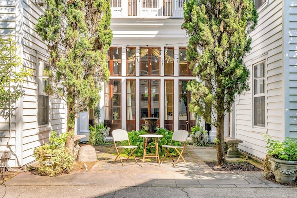 Unwind in the picturesque courtyard, a shared space where lush greenery, a peaceful koi pond, and cozy seating create the ultimate escape for relaxation, dining, or working.