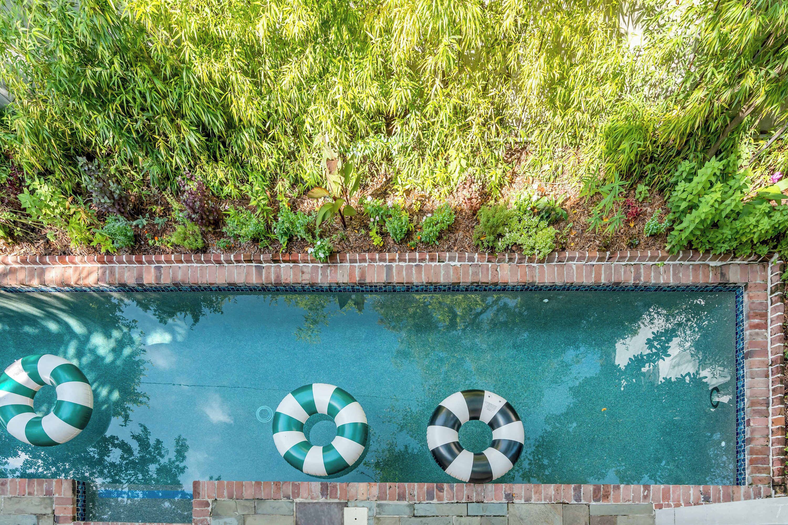 Una piscina rectangular con tres flotadores a rayas.