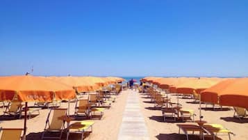 Relax on the beach with comfortable sun loungers and matching umbrellas.