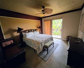 A bedroom with a bed, a bench, a desk, and a ceiling fan. - Upscale Mauna Lani, 4BDRM, 2MSTR BTHS, 5 Beds for 8, Spacious W/Bikes Near Beach (Waimea)
