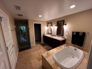 A bathroom with a large bathtub, a double sink vanity, and a walk-in shower. - Upscale Mauna Lani, 4BDRM, 2MSTR BTHS, 5 Beds for 8, Spacious W/Bikes Near Beach (Waimea)