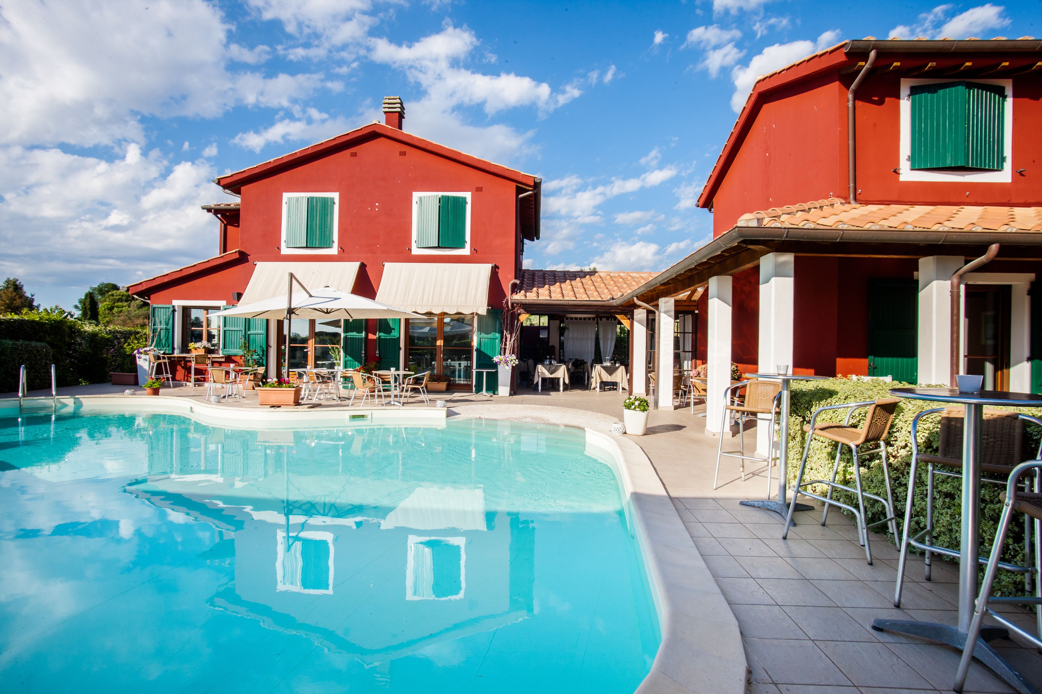 A swimming pool with a red building in the background.