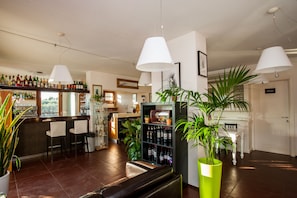 Un espace bar avec un présentoir à bouteilles de vin, des sièges et un piano.