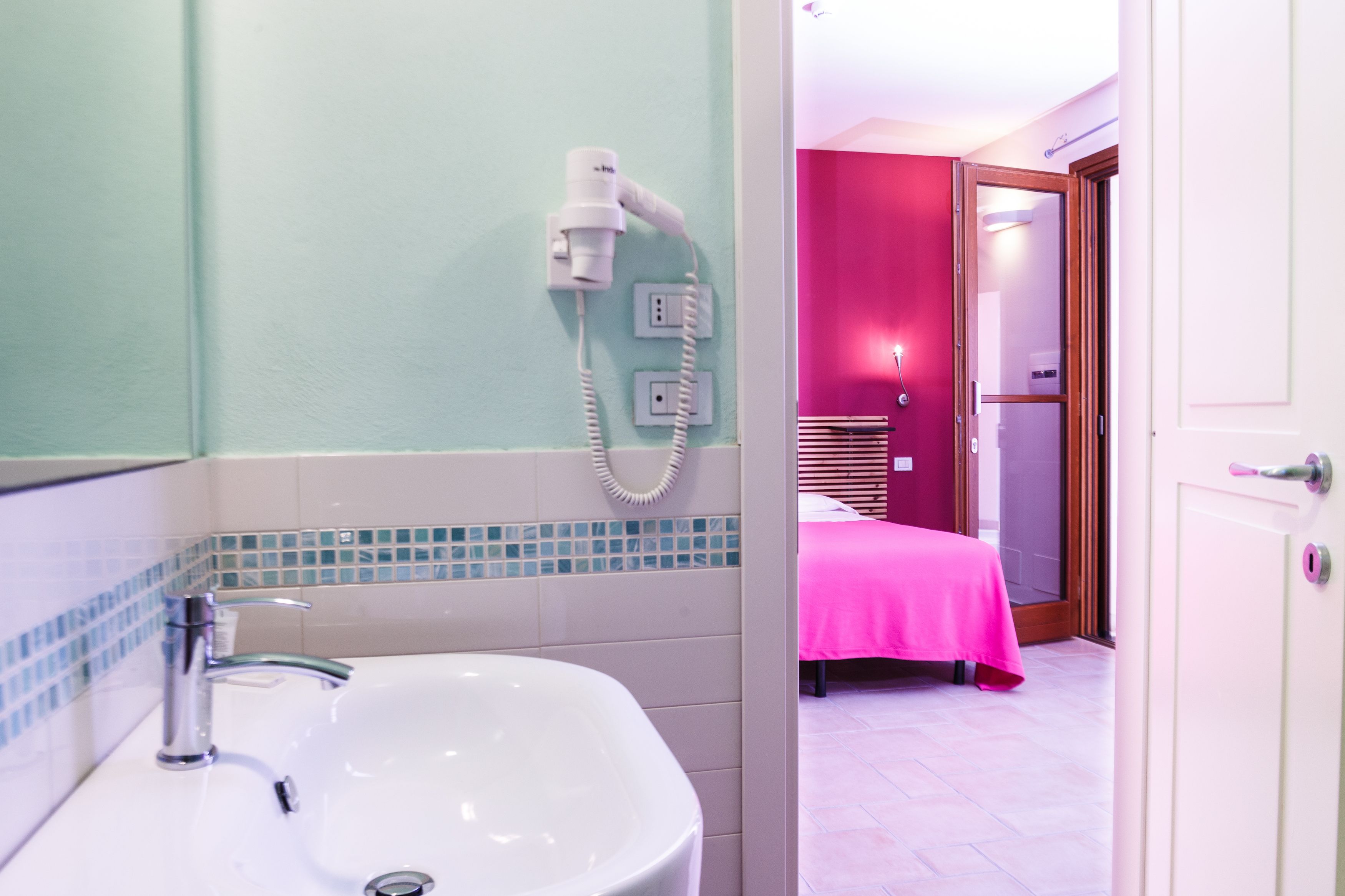 Une salle de bain équipée d’un lavabo, d’un sèche-cheveux et d’un miroir.