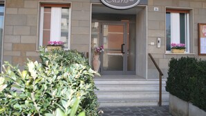 Entrada de un edificio con un letrero que dice 'Albergo Mario da' y el número '16' sobre la puerta.