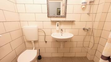 Un baño con inodoro, lavabo y ducha.