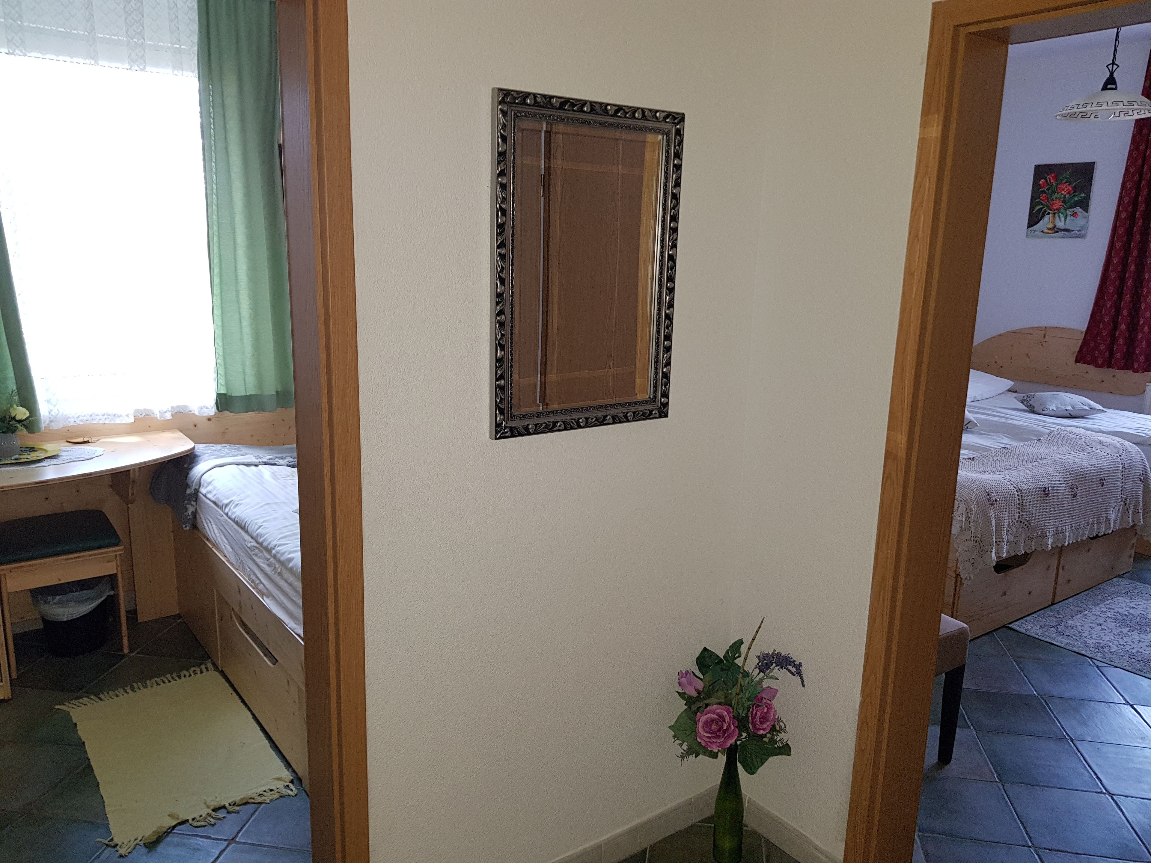 Ein Schlafzimmer mit einem Bett, einem Schreibtisch und einem Spiegel an der Wand.