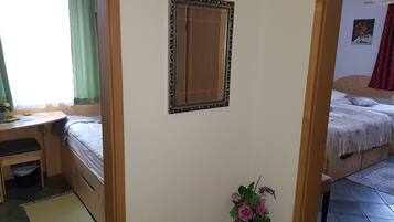 Ein Schlafzimmer mit einem Bett, einem Schreibtisch und einem Spiegel an der Wand.
