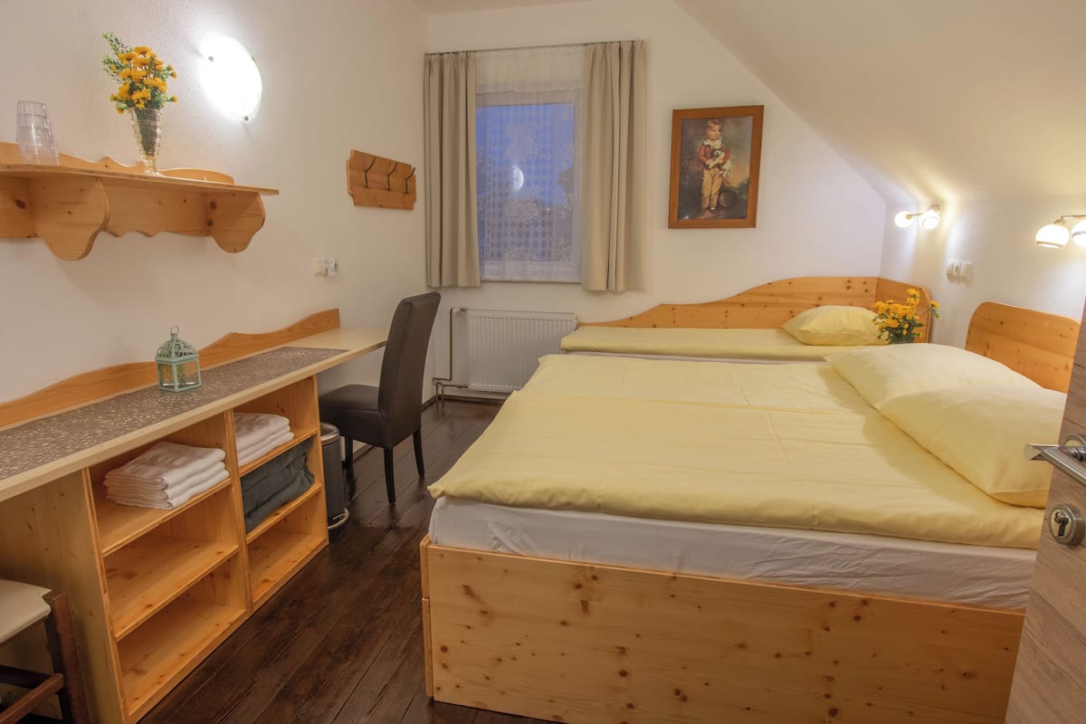 A room with a wooden bed, a desk, a chair, and a radiator.