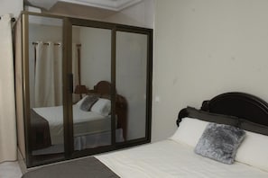 Ein Schlafzimmer mit einem Bett, einer Schiebetür und einem Nachttisch.