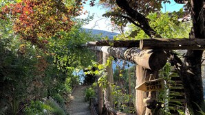 A wooden pathway leading to a sign labeled "euest SUTITE." - Maple Bay beachfront suite, just steps to your private beach patio (Duncan)
