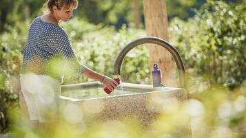 A person using a water fountain outdoors.