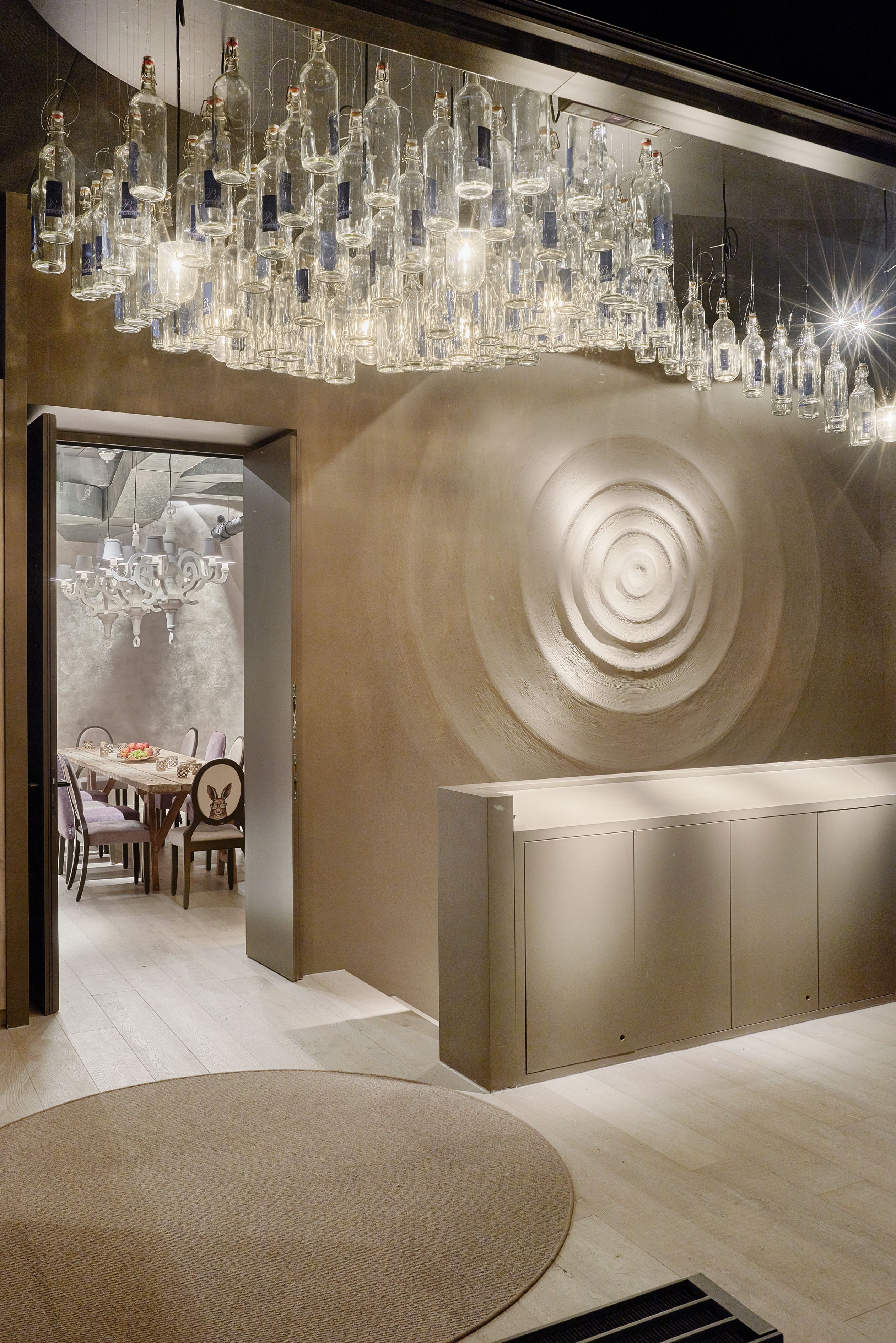 Ein modernes Interieur mit einem einzigartigen Wanddesign, einer Essecke und einer hängenden Leuchte.